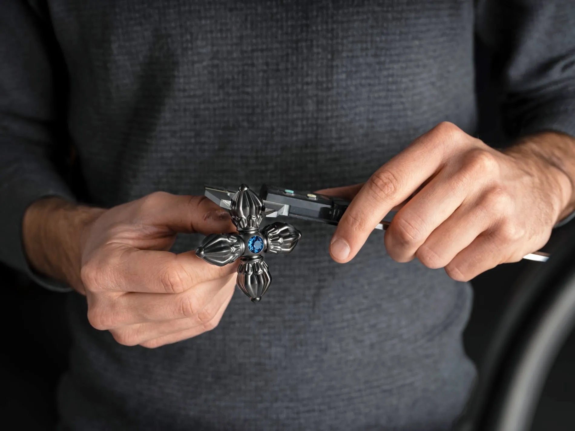 Close-up of hands measuring a faucet handle with Shamballa Jewels using a caliper.