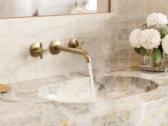 AXOR One washbasin faucet in Brushed Brass, installed in a bathroom with natural materials.